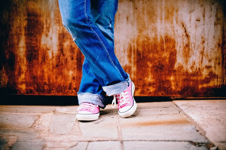 Onderkant persoon benen jeans sneakers Pixabay - pubers
